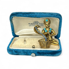 Vintage Hattie Carnegie snake charmer brooch with turquoise cabochons and blue rhinestones, gold tone metal, signed with copyright mark, 1960s figural costume jewelry.