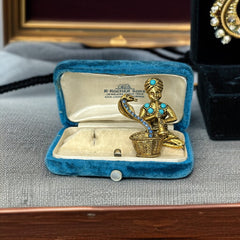 Vintage Hattie Carnegie snake charmer brooch with turquoise cabochons and blue rhinestones, gold tone metal, signed with copyright mark, 1960s figural costume jewelry.