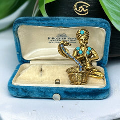 Vintage Hattie Carnegie snake charmer brooch with turquoise cabochons and blue rhinestones, gold tone metal, signed with copyright mark, 1960s figural costume jewelry.