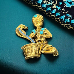 Vintage Hattie Carnegie snake charmer brooch with turquoise cabochons and blue rhinestones, gold tone metal, signed with copyright mark, 1960s figural costume jewelry.