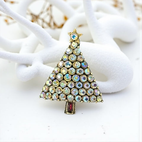 Vintage Hollycraft Christmas tree brooch with clear Aurora Borealis rhinestones in a gold-tone setting, featuring a gold star at the top and a red rhinestone base. Signed on the reverse and measuring approximately 1 3/8 inches tall by 1 inch wide.