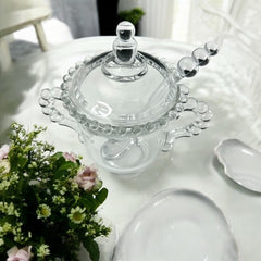 A vintage Imperial Candlewick pattern glass condiment jar set, featuring a handled jar, a fitted glass lid, and a matching glass spoon. Made between 1936 and 1984, the set is in excellent vintage condition and showcases the iconic bead design of the Candlewick collection.