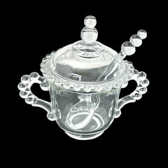 A vintage Imperial Candlewick pattern glass condiment jar set, featuring a handled jar, a fitted glass lid, and a matching glass spoon. Made between 1936 and 1984, the set is in excellent vintage condition and showcases the iconic bead design of the Candlewick collection.