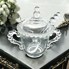 A vintage Imperial Candlewick pattern glass condiment jar set, featuring a handled jar, a fitted glass lid, and a matching glass spoon. Made between 1936 and 1984, the set is in excellent vintage condition and showcases the iconic bead design of the Candlewick collection.