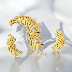 Vintage Jomaz feather brooch and earrings set from the early 1960s, featuring clear pave rhinestones set in silver-tone metal for the quill and textured gold-plated metal for the feather. Signed Jomaz on the back, in very good vintage condition with all original rhinestones present.