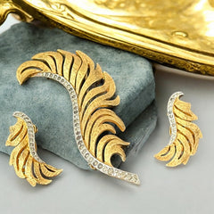 Vintage Jomaz feather brooch and earrings set from the early 1960s, featuring clear pave rhinestones set in silver-tone metal for the quill and textured gold-plated metal for the feather. Signed Jomaz on the back, in very good vintage condition with all original rhinestones present.