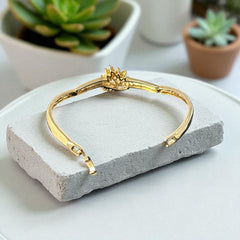 Vintage 1990s gold tone bracelet with curved links and a single jonquil marquise rhinestone flower centerpiece, elegant and gently worn.