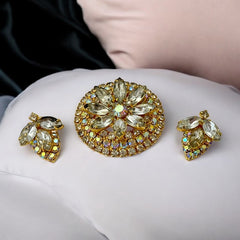 Verified Juliana #1402 vintage clear rhinestone and gold-tone floral brooch with matching clip-on earrings. The brooch features dimensional layered rings of clear chaton and AB rhinestones, with marquise rhinestones encircling the center. Earrings showcase a leaf-shaped design with marquise rhinestones and AB chaton accents. Mid-century elegance from the late 1950s or early 1960s.