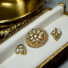 Verified Juliana #1402 vintage clear rhinestone and gold-tone floral brooch with matching clip-on earrings. The brooch features dimensional layered rings of clear chaton and AB rhinestones, with marquise rhinestones encircling the center. Earrings showcase a leaf-shaped design with marquise rhinestones and AB chaton accents. Mid-century elegance from the late 1950s or early 1960s.