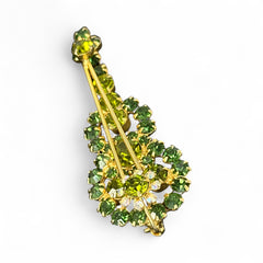 Vintage Juliana violin brooch in gold tone metal with green and peridot rhinestones, featuring layered construction and floral accents; verified design #3151 from the 1960s, shown from front and back.