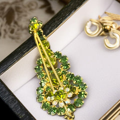 Vintage Juliana violin brooch in gold tone metal with green and peridot rhinestones, featuring layered construction and floral accents; verified design #3151 from the 1960s, shown from front and back.