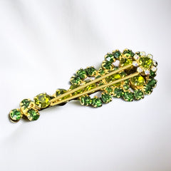 Vintage Juliana violin brooch in gold tone metal with green and peridot rhinestones, featuring layered construction and floral accents; verified design #3151 from the 1960s, shown from front and back.