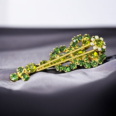 Vintage Juliana violin brooch in gold tone metal with green and peridot rhinestones, featuring layered construction and floral accents; verified design #3151 from the 1960s, shown from front and back.