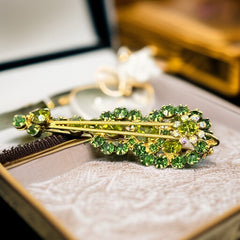 Vintage Juliana violin brooch in gold tone metal with green and peridot rhinestones, featuring layered construction and floral accents; verified design #3151 from the 1960s, shown from front and back.
