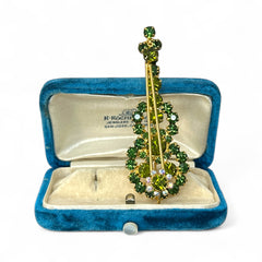 Vintage Juliana violin brooch in gold tone metal with green and peridot rhinestones, featuring layered construction and floral accents; verified design #3151 from the 1960s, shown from front and back.