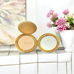 Vintage 1950s Kigu gold-tone powder compact with guilloché moiré lid, original puff, and mirror—collectible beauty accessory with timeless charm.