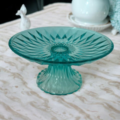 A vibrant aqua blue pressed glass footed dish with a diamond pattern, versatile for serving desserts, fruit, or candy, mid-century design.