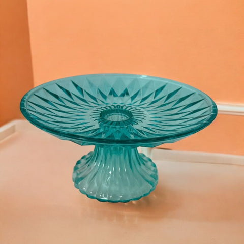 A vibrant aqua blue pressed glass footed dish with a diamond pattern, versatile for serving desserts, fruit, or candy, mid-century design.
