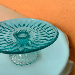 A vibrant aqua blue pressed glass footed dish with a diamond pattern, versatile for serving desserts, fruit, or candy, mid-century design.