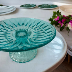 A vibrant aqua blue pressed glass footed dish with a diamond pattern, versatile for serving desserts, fruit, or candy, mid-century design.