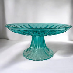 A vibrant aqua blue pressed glass footed dish with a diamond pattern, versatile for serving desserts, fruit, or candy, mid-century design.