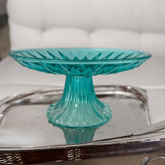 A vibrant aqua blue pressed glass footed dish with a diamond pattern, versatile for serving desserts, fruit, or candy, mid-century design.