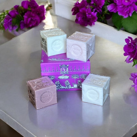 Fuchsia toile de Jouy gift box with intricate patterns, containing four artisanal Marseille cube soaps in Fig, Jasmine, Rose, and Lily of the Valley fragrances.