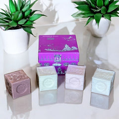 Fuchsia toile de Jouy gift box with intricate patterns, containing four artisanal Marseille cube soaps in Fig, Jasmine, Rose, and Lily of the Valley fragrances.