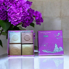 Fuchsia toile de Jouy gift box with intricate patterns, containing four artisanal Marseille cube soaps in Fig, Jasmine, Rose, and Lily of the Valley fragrances.