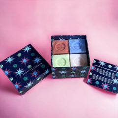 Gift box featuring a charming Moon and Sun design on a midnight blue background. Contains four artisanal Marseille cube soaps in Violet, Rose, Verbena, and Red Berries fragrances.