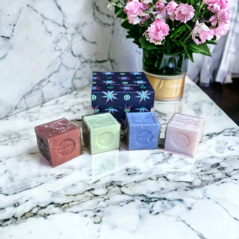 Gift box featuring a charming Moon and Sun design on a midnight blue background. Contains four artisanal Marseille cube soaps in Violet, Rose, Verbena, and Red Berries fragrances.