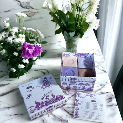 Purple Toile de Jouy gift box featuring intricate patterns, containing four artisanal Marseille cube soaps in Lilac, Lavender, Fig, and Rose fragrances.