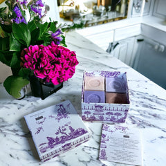 Purple Toile de Jouy gift box featuring intricate patterns, containing four artisanal Marseille cube soaps in Lilac, Lavender, Fig, and Rose fragrances.