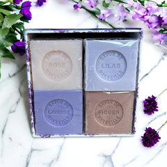 Purple Toile de Jouy gift box featuring intricate patterns, containing four artisanal Marseille cube soaps in Lilac, Lavender, Fig, and Rose fragrances.