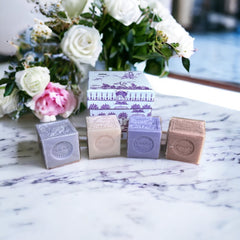Purple Toile de Jouy gift box featuring intricate patterns, containing four artisanal Marseille cube soaps in Lilac, Lavender, Fig, and Rose fragrances.