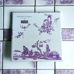 Purple Toile de Jouy gift box featuring intricate patterns, containing four artisanal Marseille cube soaps in Lilac, Lavender, Fig, and Rose fragrances.