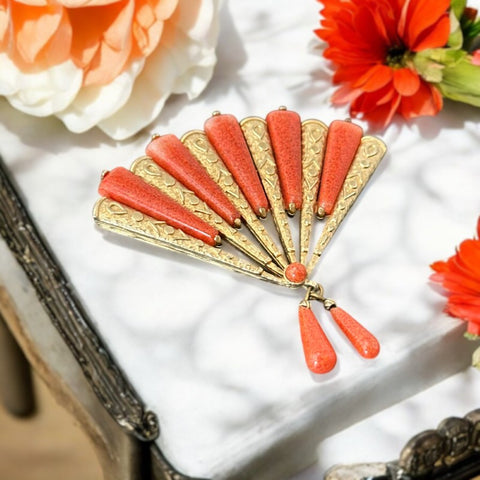 Vintage Marvella brooch from the 1960s, designed in an oriental fan shape with textured gold-tone metal and faux coral glass inserts. Two coral glass drops dangle elegantly from the bottom. Signed Marvella with a copyright mark at the back, in very good vintage condition.