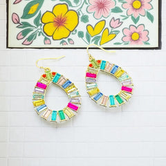 Christian Siriano New York teardrop dangle earrings with multicolor baguette-cut cubic zirconia stones in a vibrant, symmetrical design.