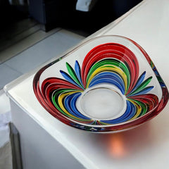 A small, triangular vintage Murano glass trinket dish from the 1990s, featuring vibrant red, green, blue, and yellow colors. The multicolored Venetian glass dish has a tiny chip on the rim but remains a striking and functional decorative piece.