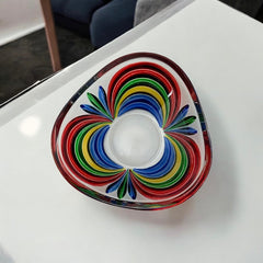 A small, triangular vintage Murano glass trinket dish from the 1990s, featuring vibrant red, green, blue, and yellow colors. The multicolored Venetian glass dish has a tiny chip on the rim but remains a striking and functional decorative piece.