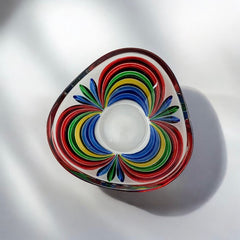 A small, triangular vintage Murano glass trinket dish from the 1990s, featuring vibrant red, green, blue, and yellow colors. The multicolored Venetian glass dish has a tiny chip on the rim but remains a striking and functional decorative piece.