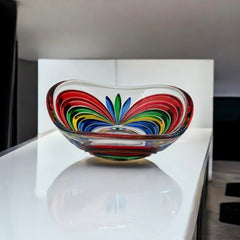 A small, triangular vintage Murano glass trinket dish from the 1990s, featuring vibrant red, green, blue, and yellow colors. The multicolored Venetian glass dish has a tiny chip on the rim but remains a striking and functional decorative piece.