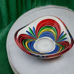 A small, triangular vintage Murano glass trinket dish from the 1990s, featuring vibrant red, green, blue, and yellow colors. The multicolored Venetian glass dish has a tiny chip on the rim but remains a striking and functional decorative piece.
