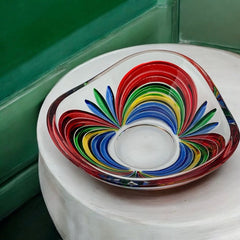A small, triangular vintage Murano glass trinket dish from the 1990s, featuring vibrant red, green, blue, and yellow colors. The multicolored Venetian glass dish has a tiny chip on the rim but remains a striking and functional decorative piece.