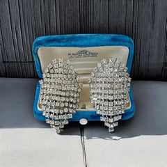 Pair of vintage 1950s Musi clear rhinestone chain shoe clips with an elongated shape, featuring triangular details at the top and bottom. The top rhinestone chains are soldered, while the bottom section moves for added sparkle. Signed 'Musi' on the back, in very good vintage condition with one slightly darkened rhinestone.