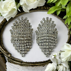 Pair of vintage 1950s Musi clear rhinestone chain shoe clips with an elongated shape, featuring triangular details at the top and bottom. The top rhinestone chains are soldered, while the bottom section moves for added sparkle. Signed 'Musi' on the back, in very good vintage condition with one slightly darkened rhinestone.