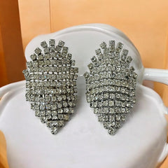 Pair of vintage 1950s Musi clear rhinestone chain shoe clips with an elongated shape, featuring triangular details at the top and bottom. The top rhinestone chains are soldered, while the bottom section moves for added sparkle. Signed 'Musi' on the back, in very good vintage condition with one slightly darkened rhinestone.