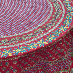 Round Provence-style cotton tablecloth by Le Cluny, featuring a vibrant red background with yellow mimosa and black olive detailing. Measures 70 inches in diameter, made in France, suitable for indoor and outdoor use, and machine washable for easy care.