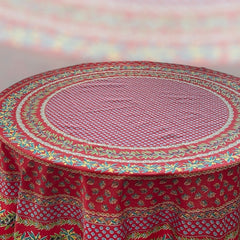 Round Provence-style cotton tablecloth by Le Cluny, featuring a vibrant red background with yellow mimosa and black olive detailing. Measures 70 inches in diameter, made in France, suitable for indoor and outdoor use, and machine washable for easy care.