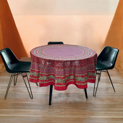 Round Provence-style cotton tablecloth by Le Cluny, featuring a vibrant red background with yellow mimosa and black olive detailing. Measures 70 inches in diameter, made in France, suitable for indoor and outdoor use, and machine washable for easy care.